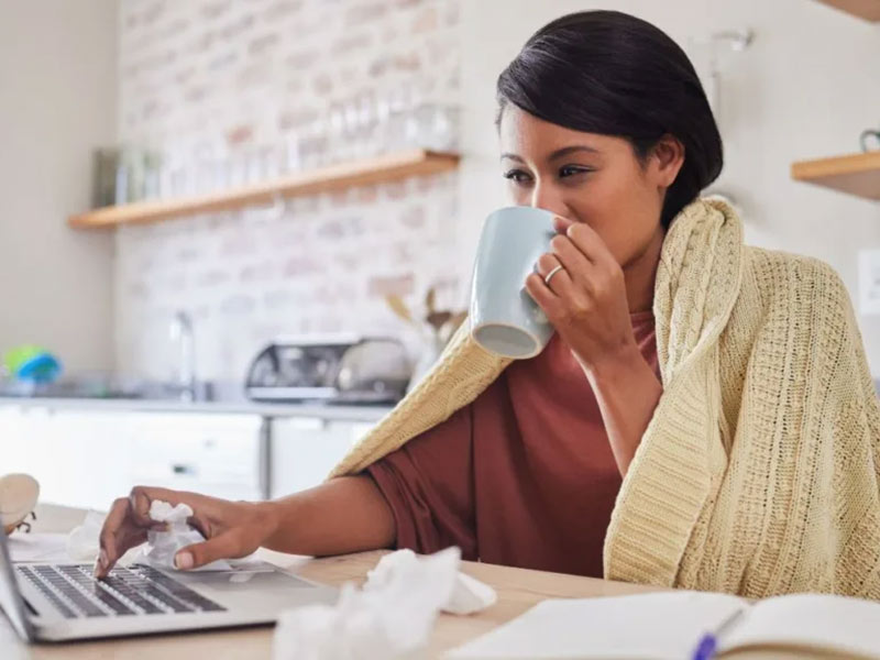 women drinking a coffee while working and sick